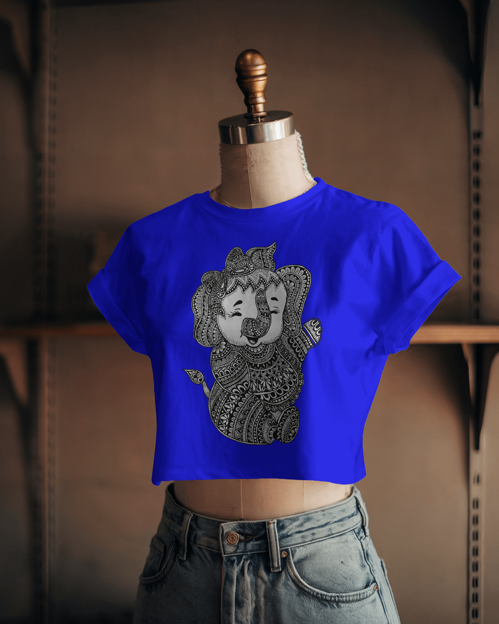 Blue crop top with a lion design on a mannequin against a blurred background