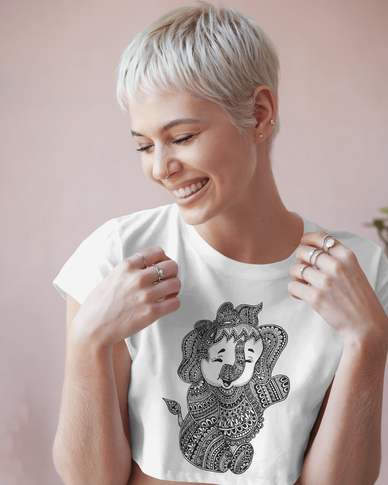 Woman wearing a white t-shirt with a black graphic design on a pink background