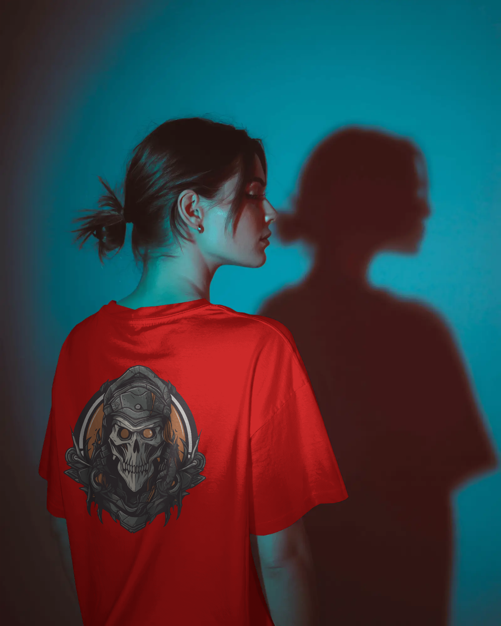Person wearing a red t-shirt with a skull design, standing against a blue background.