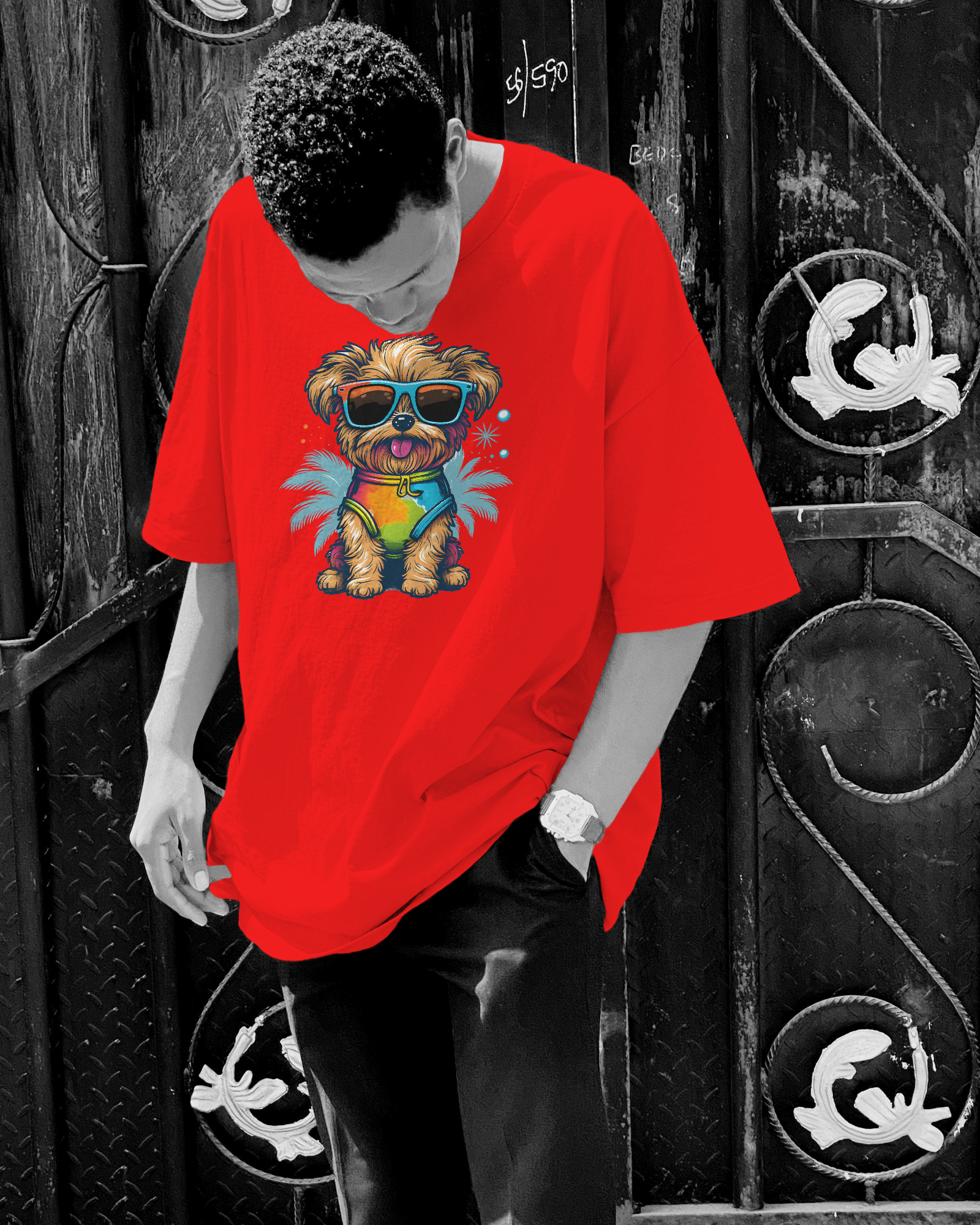 Person wearing a red t-shirt with a colorful dog graphic in front of a black metal door.