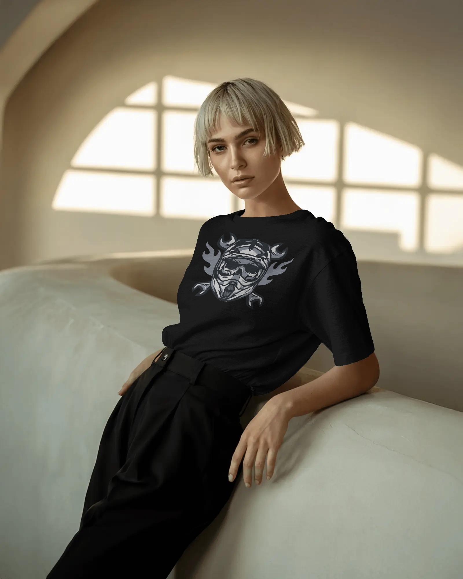 Woman wearing a black outfit with a white design, sitting on a light-colored couch.