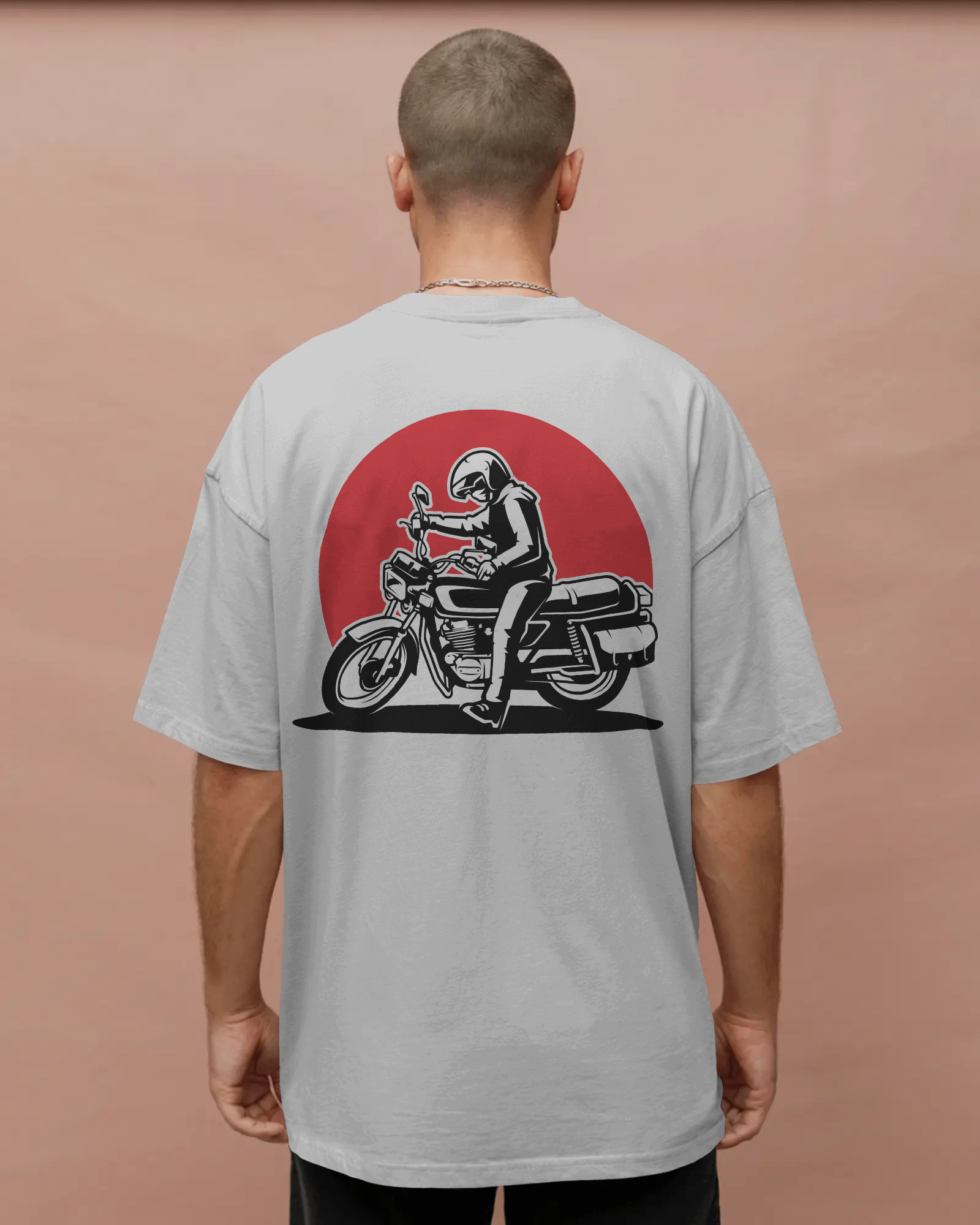 Person wearing a gray t-shirt with a graphic of a person on a motorcycle on the back against a pinkish-brown background by Tanabana A Manoram