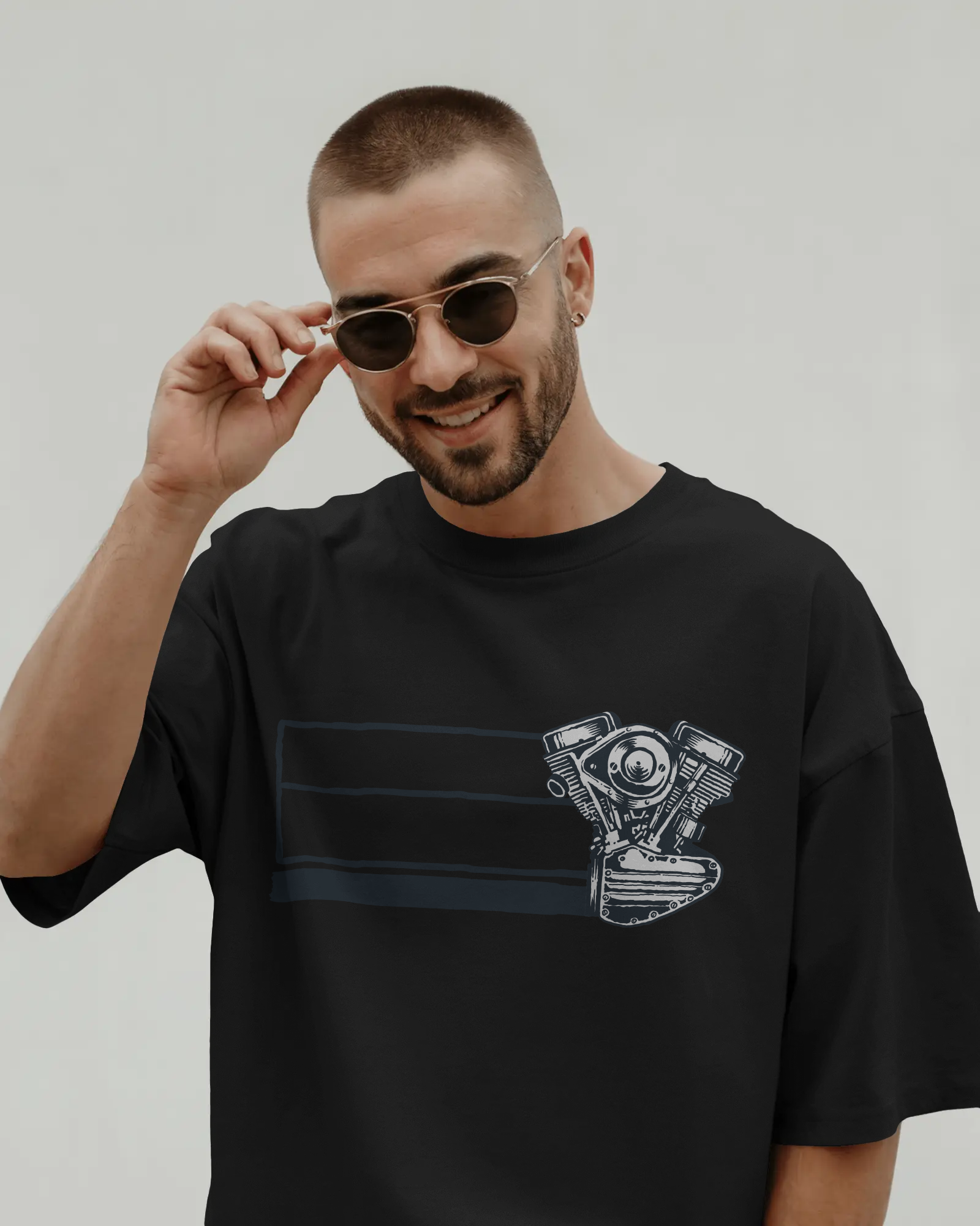 Man wearing a black t-shirt with a graphic design on a plain background