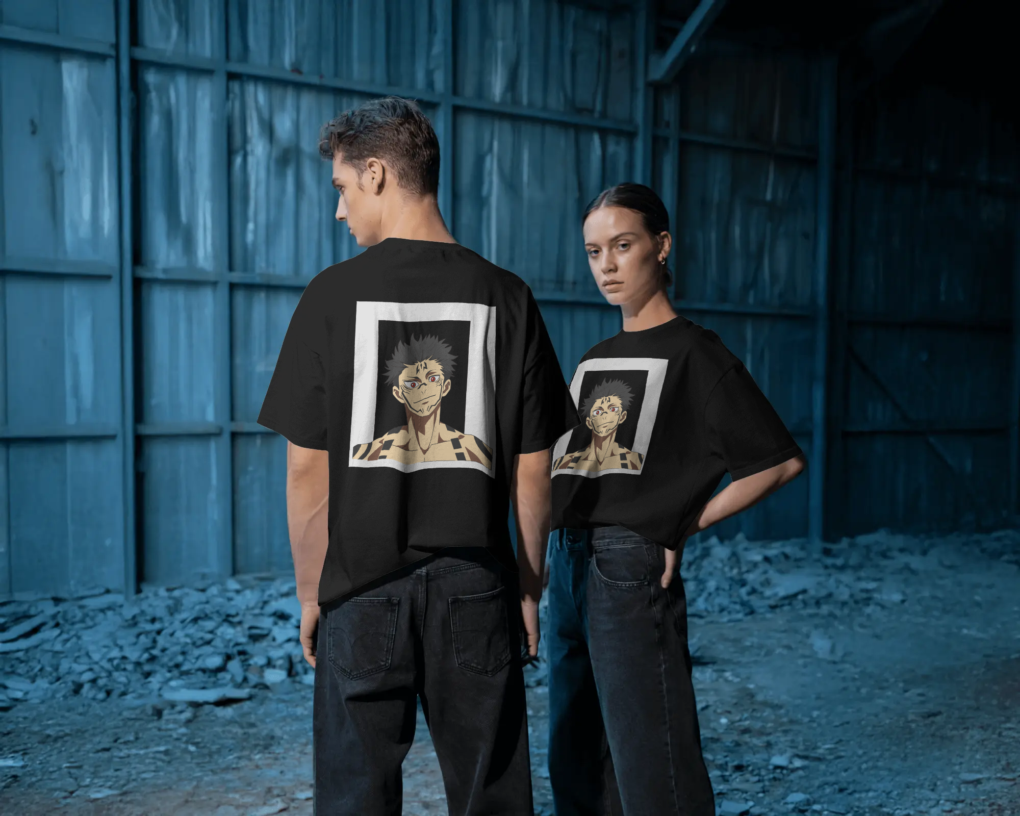 Two people wearing black t-shirts with graphic designs in a blue-walled room.