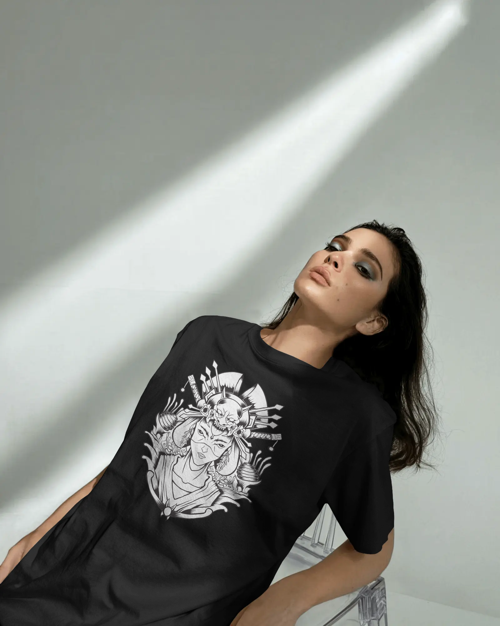 Woman wearing a black t-shirt with a white graphic design on a gray background