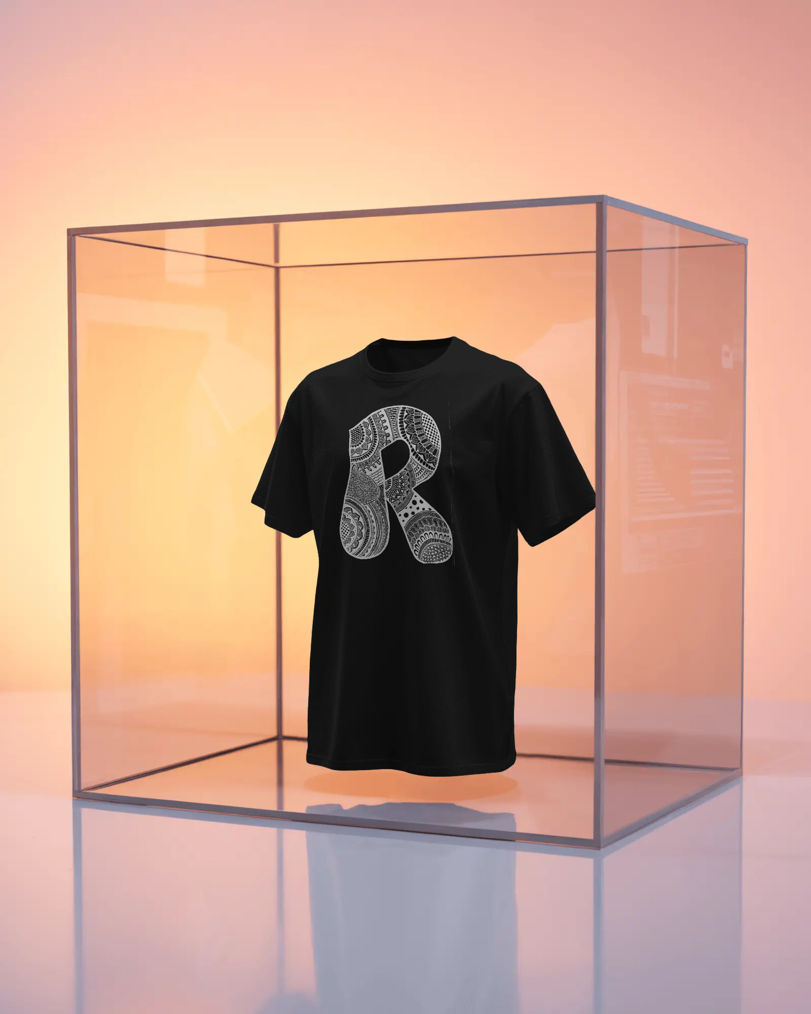 Black t-shirt with a white graphic design in a clear glass box against a gradient background
