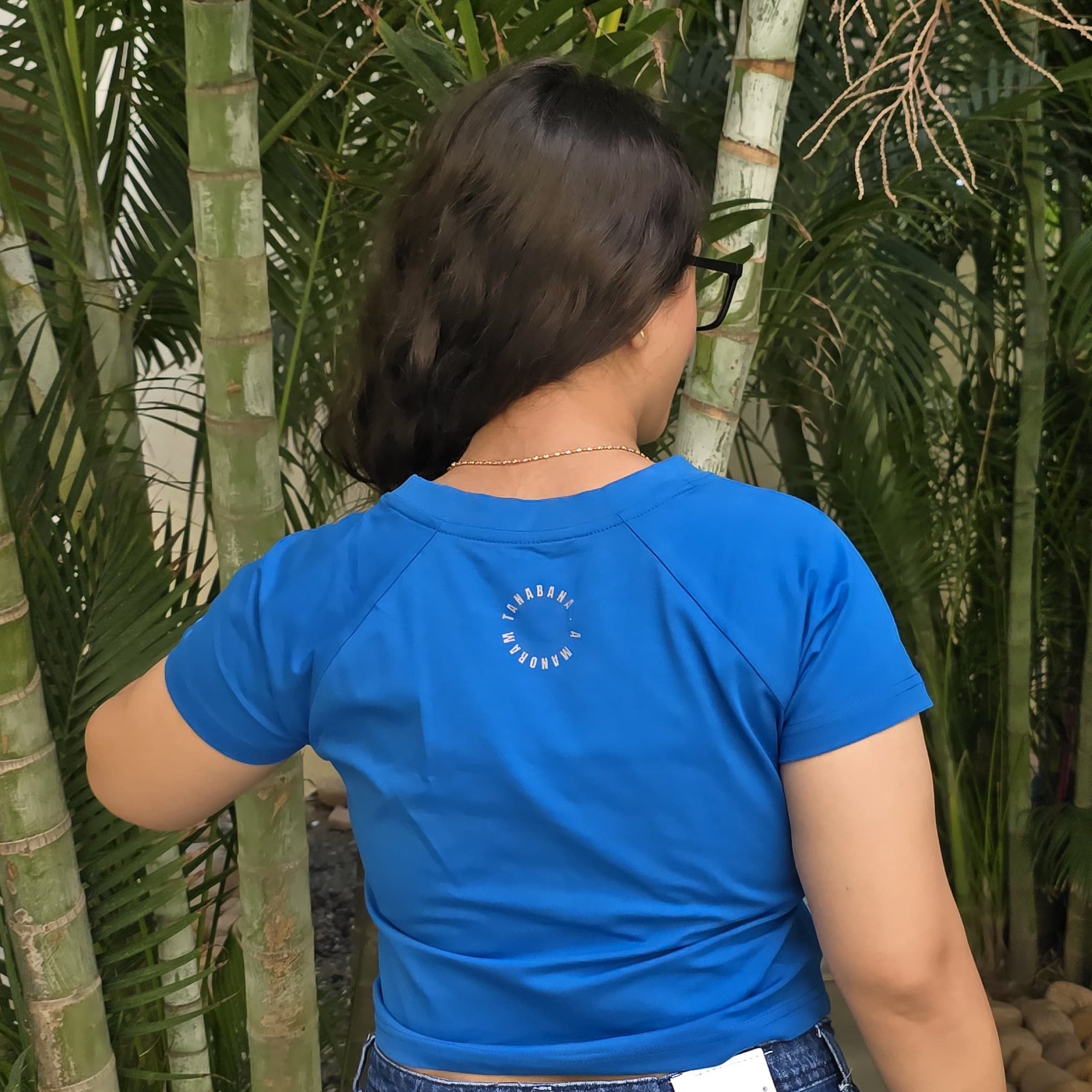 Blue crop top with colorful cat wearing headphones and sunglasses graphic print, back close view