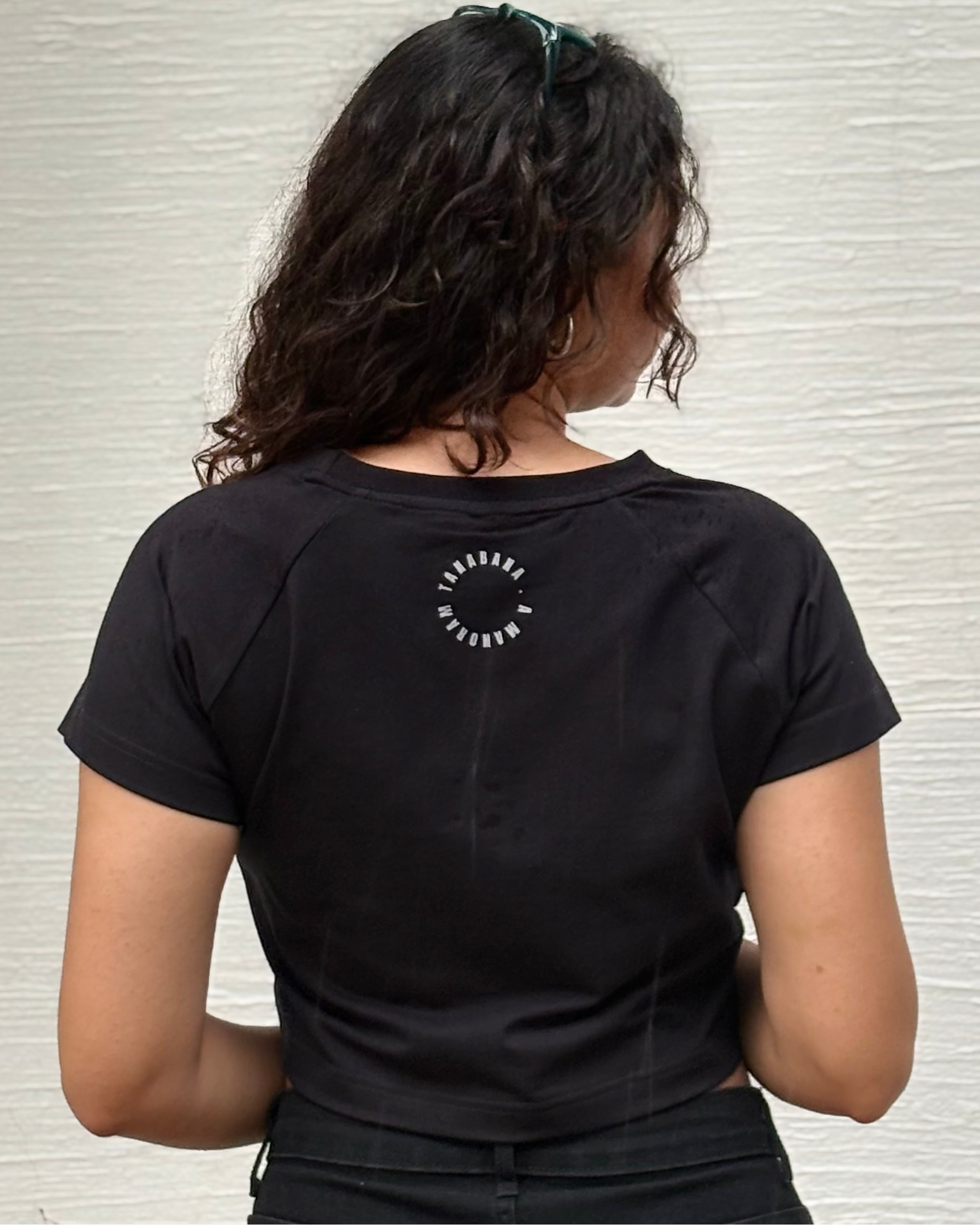 Hand-drawn mandala Baby Ganesha illustration print, back view black t-shirt worn by model - Tanabana A Manoram