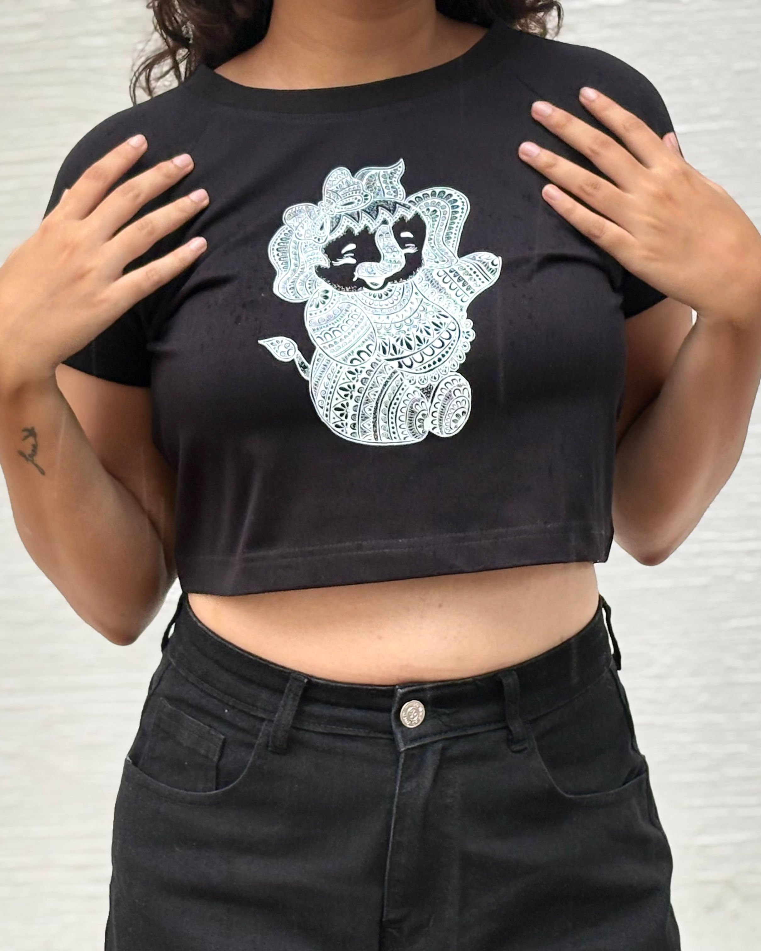 Hand-drawn mandala Baby Ganesha illustration print, front close up view black t-shirt worn by model - Tanabana A Manoram
